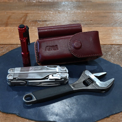 Martin harness leather case with flashlight, wrench, and Surge Leatherman tool combo