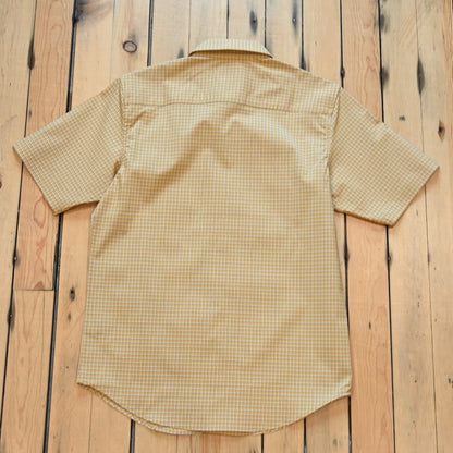 View of Kimes Ranch MC Cooper Short Sleeve Button-Up Shirt in Gold, featuring a grid plaid pattern and snap button front