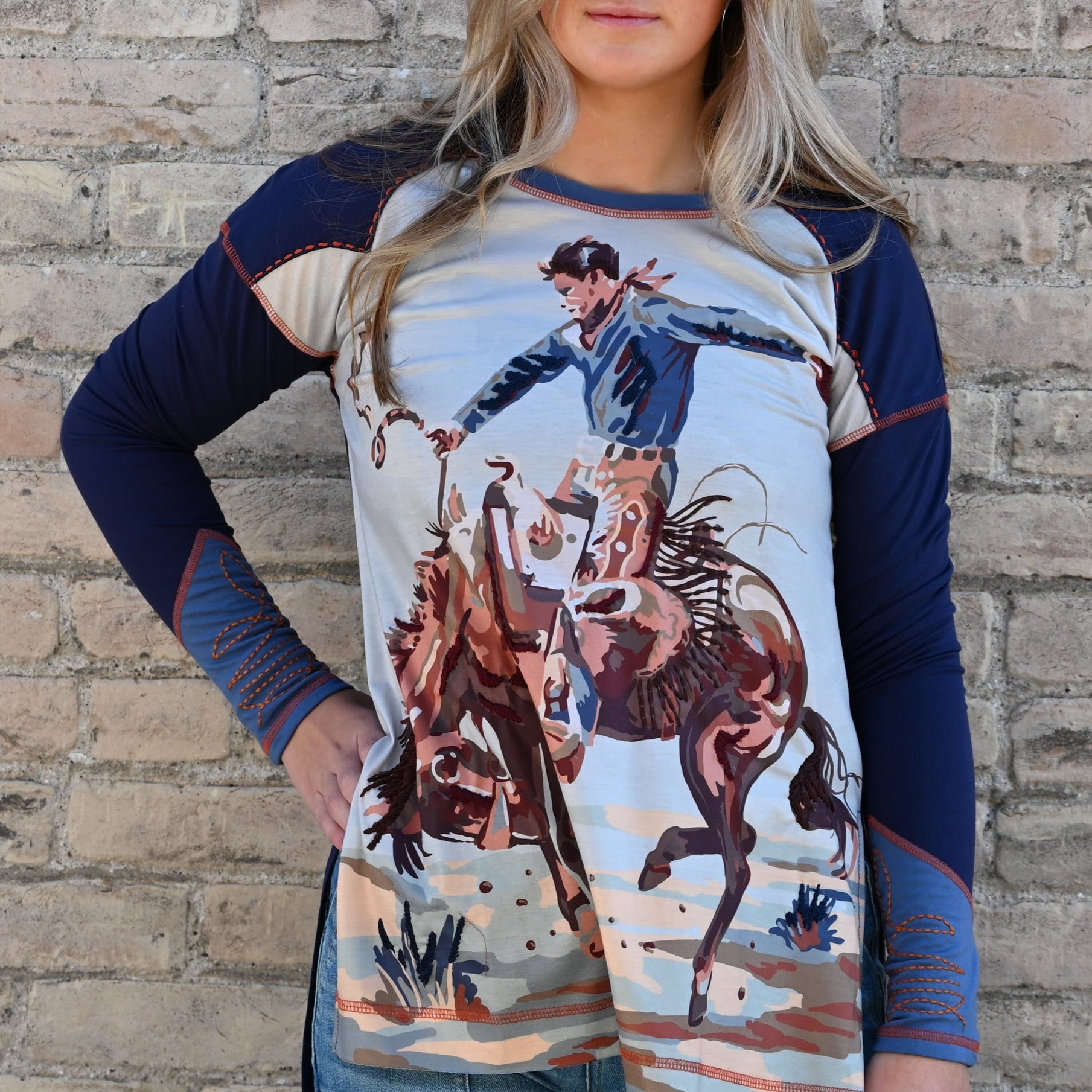 View of Double D Ranch Rodeo Top in Blue Indigo featuring a rodeo graphic and relaxed fit with a hi-low hem