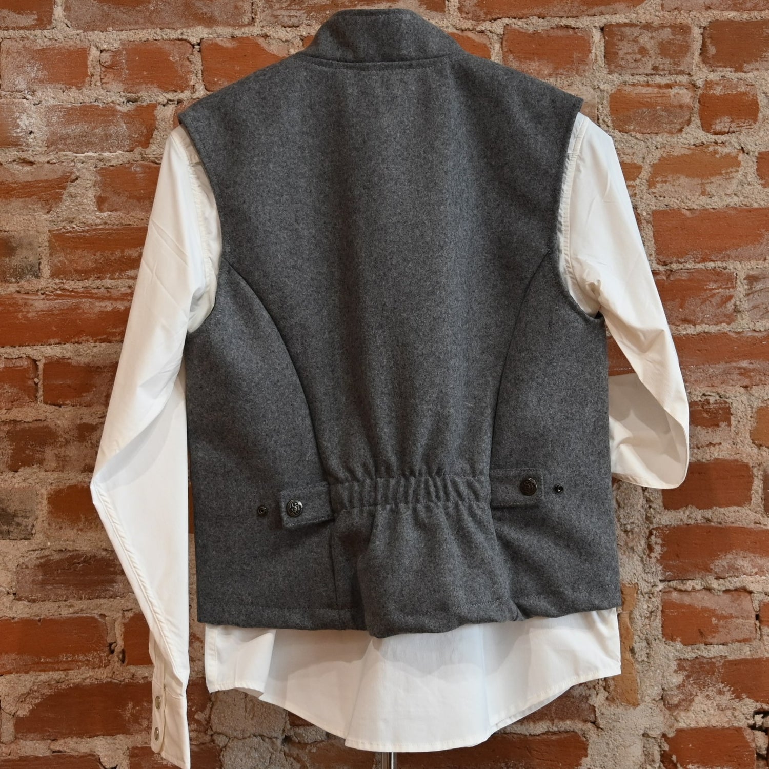 View of Schaefer grey wool vest with zip front, pockets, and adjustable back belt