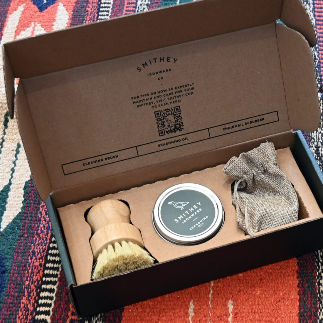 View of Smithey Ironware Cleaning & Care Kit: chainmail scrubber, seasoning oil, and cleaning brush