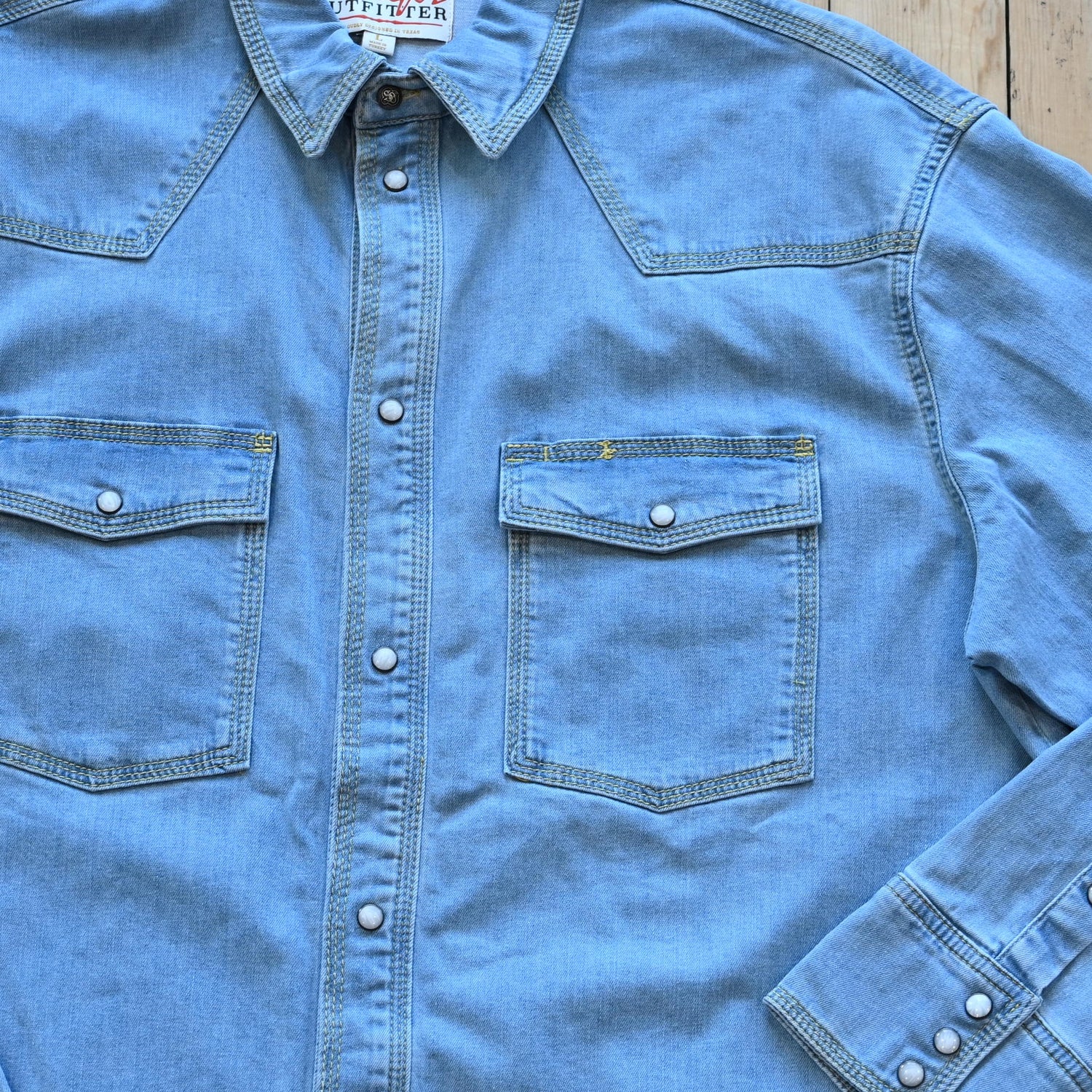 View of Schaefer denim snap shirt in dark indigo, gray, and light indigo with Western yokes and chest pockets