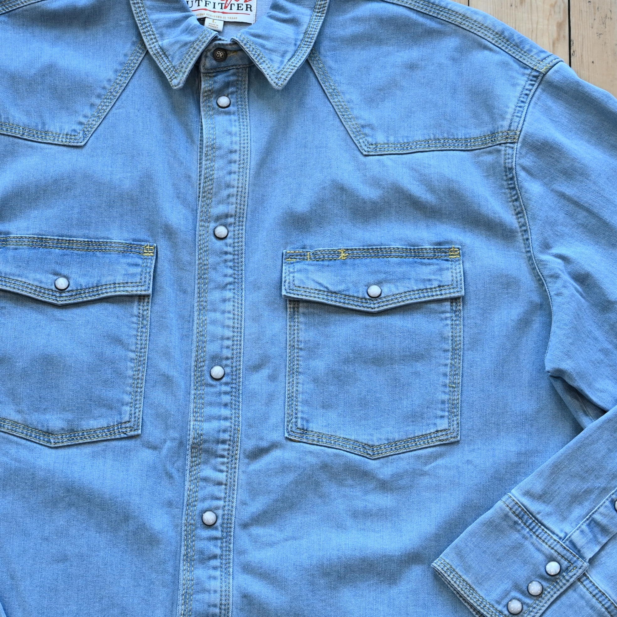 View of Schaefer denim snap shirt in dark indigo, gray, and light indigo with Western yokes and chest pockets