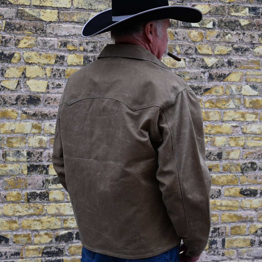 View of Schaefer ranch-style waxed cotton Mesquite Brush Jacket in oak or saddle with brass snap buttons