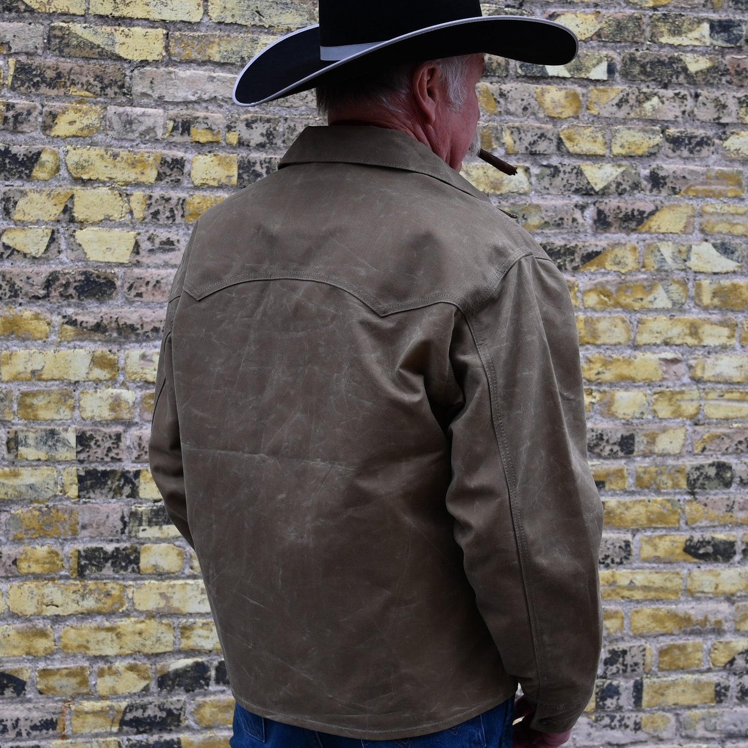 View of Schaefer ranch-style waxed cotton Mesquite Brush Jacket in oak or saddle with brass snap buttons