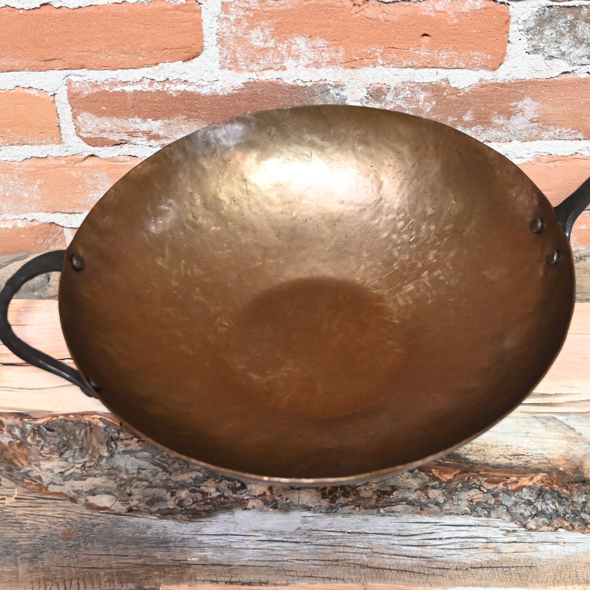 View of Smithey Ironware Carbon Steel Wok with hand-hammered surface and gooseneck handle
