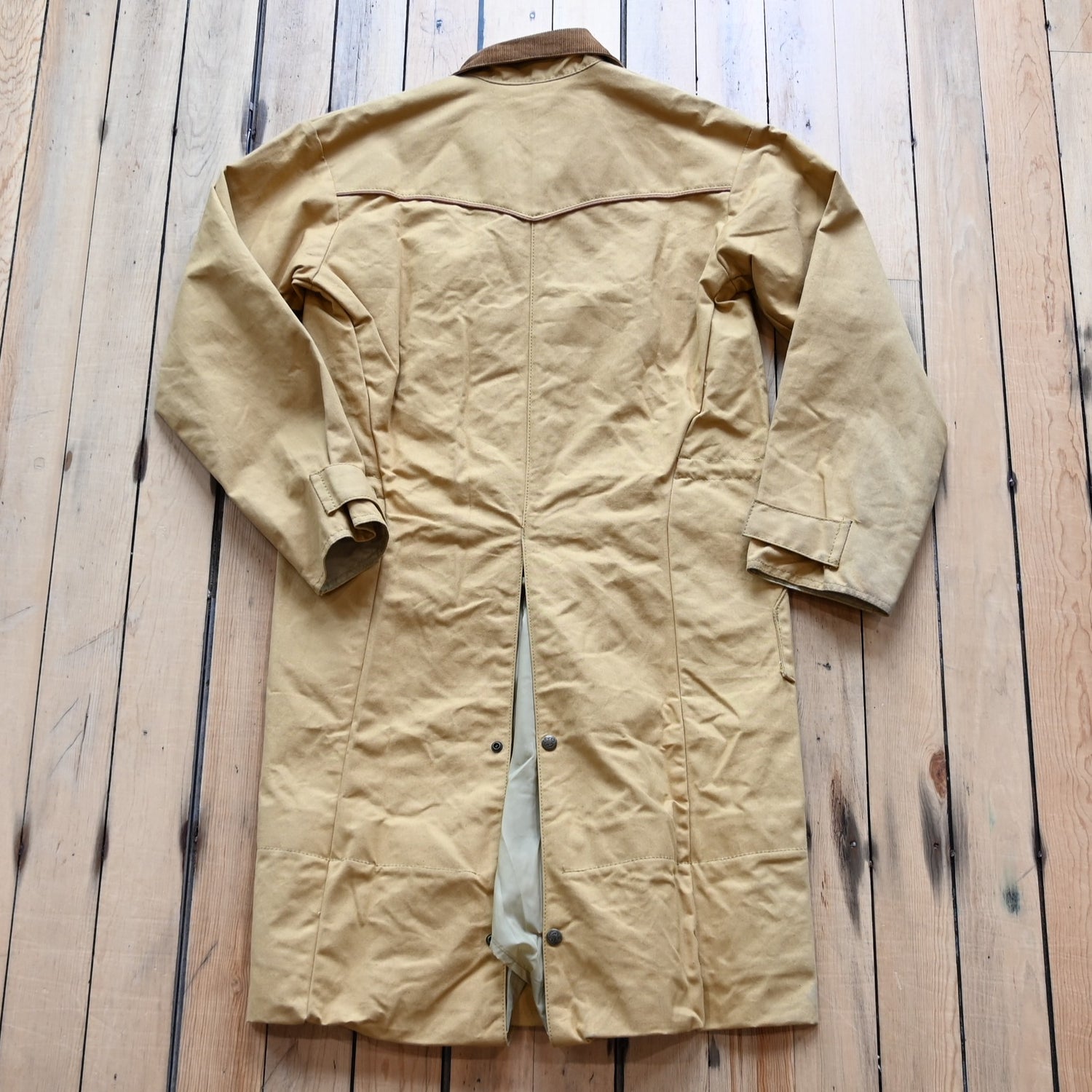 View of Schaefer canvas duster in solid suntan with corduroy collar and full-length storm flap