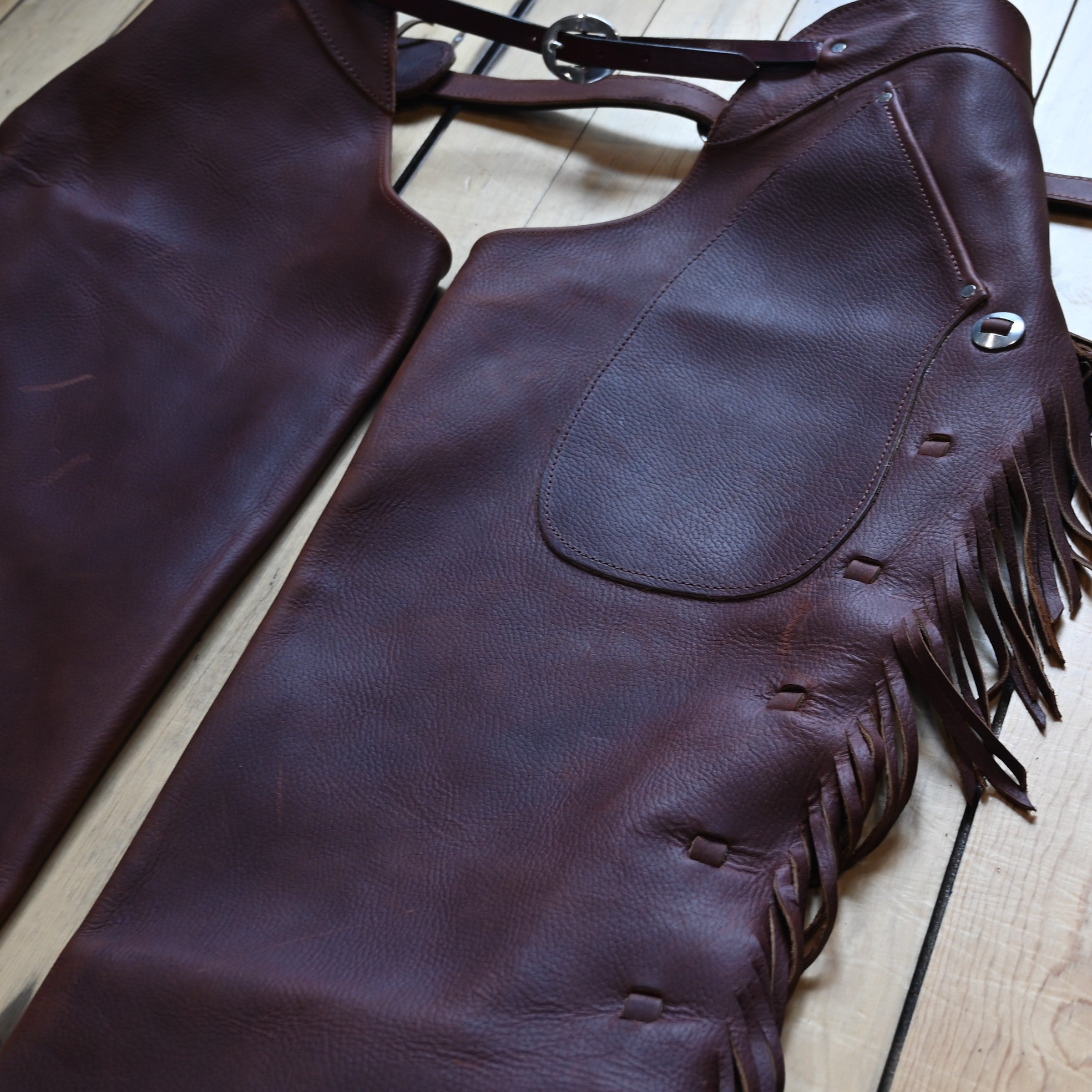 View of K Bar J Cowboy Basic Shotgun Chaps in Size Large with fringe and buckle closures