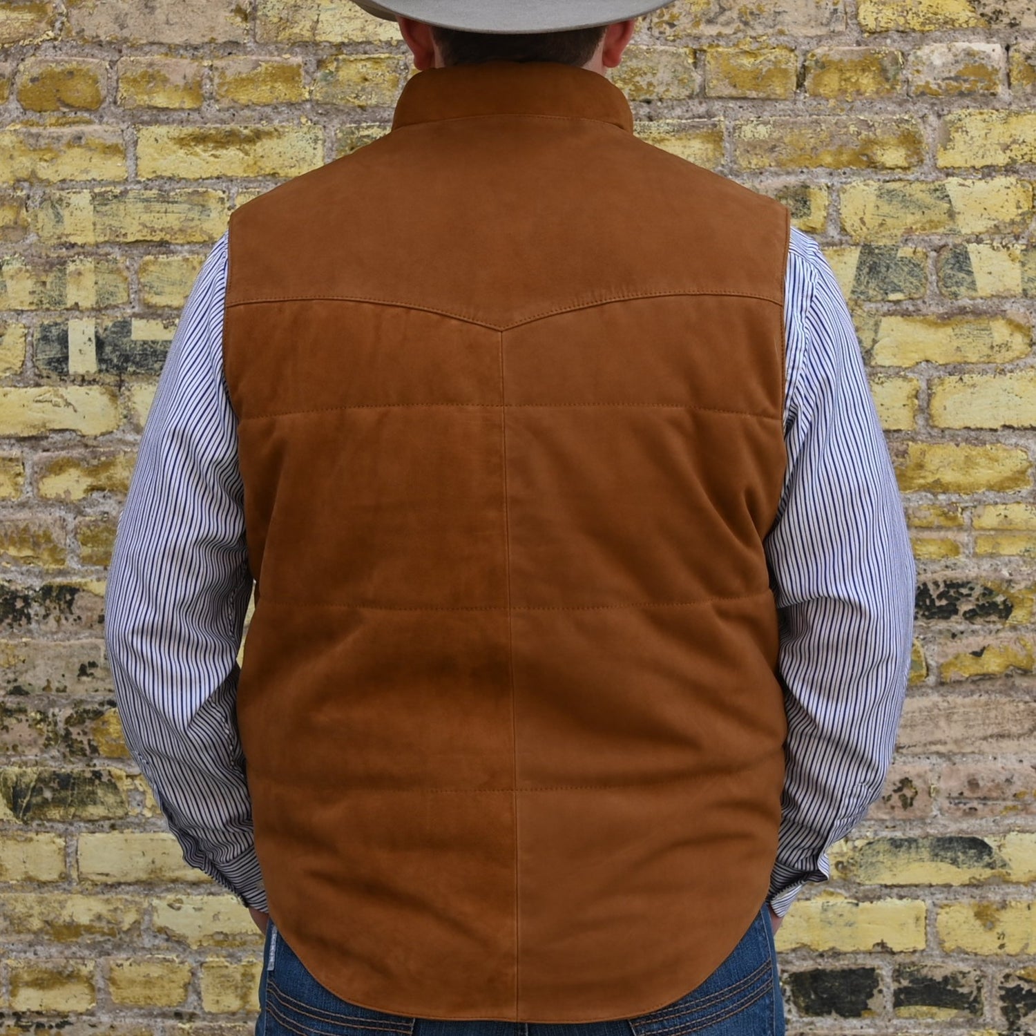 View of Schaefer men’s honey suede vest with Western yoke, fleece-lined pockets, and brass snap closure
