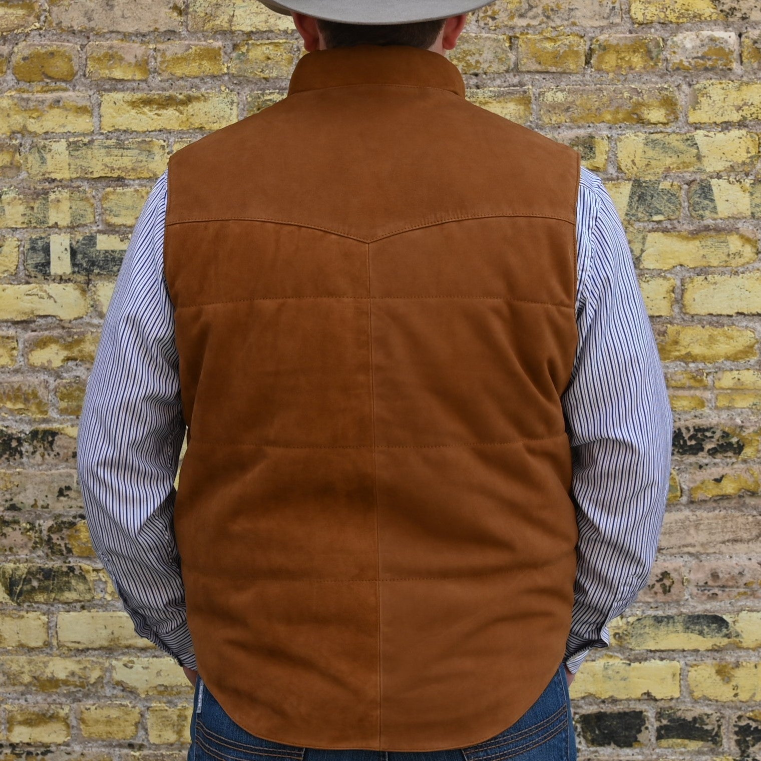 View of Schaefer men’s honey suede vest with Western yoke, fleece-lined pockets, and brass snap closure