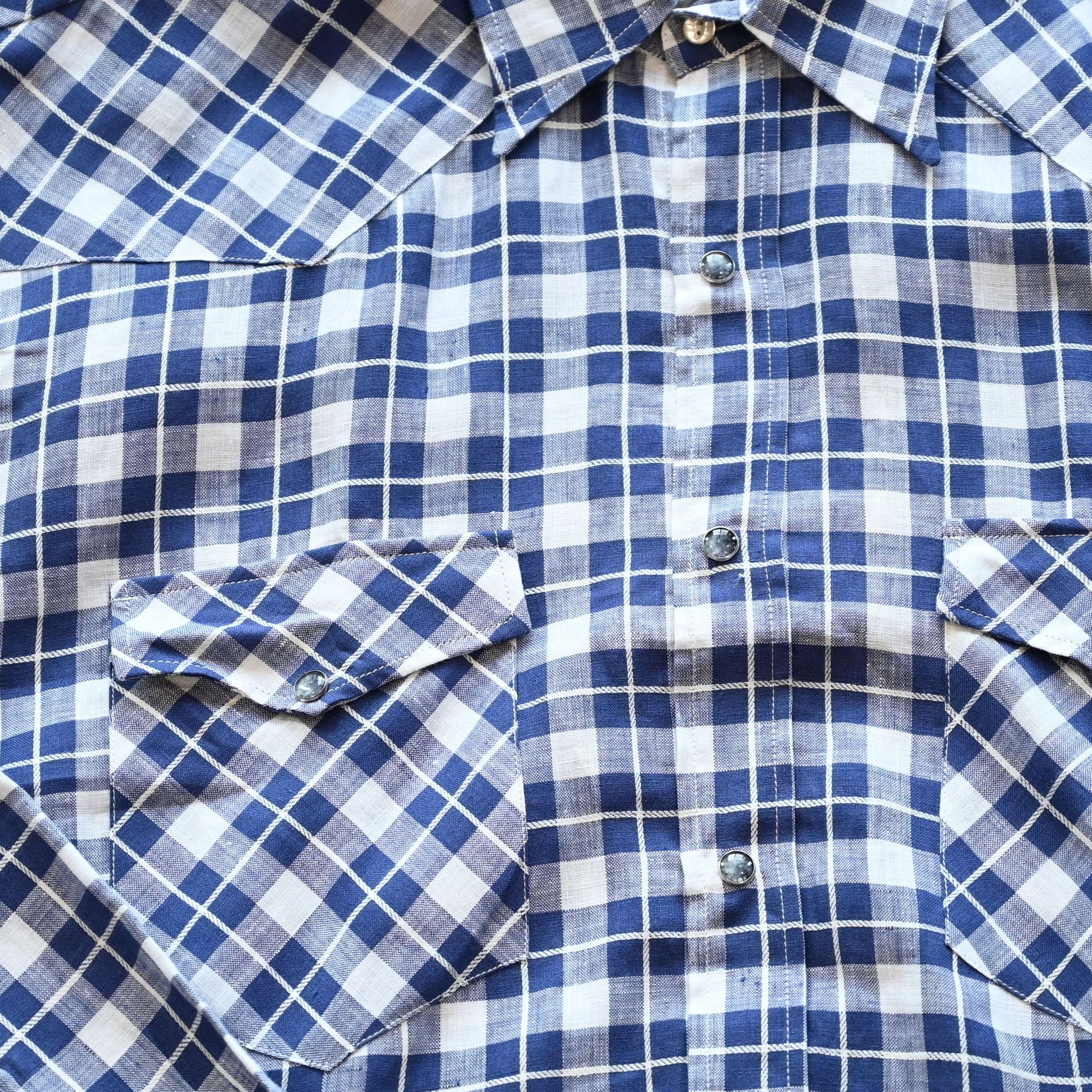 View of Blue Blanket men’s blue plaid linen Western shirt with pearl snaps and yoke detail