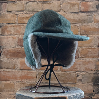 View of Filson Double Mackinaw Cap in Forest Green/Acorn and Burgundy/Dark Olive Plaid featuring shearling-lined earflaps and a 3&quot; bill