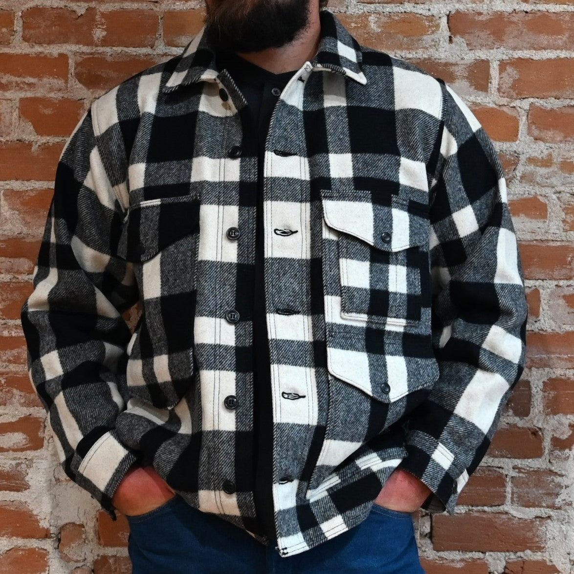 View of Filson Mackinaw Cruiser in Navy, Charcoal &amp; Natural/Black Heritage Plaid featuring button-secure front closure, adjustable cuffs, and multiple pockets