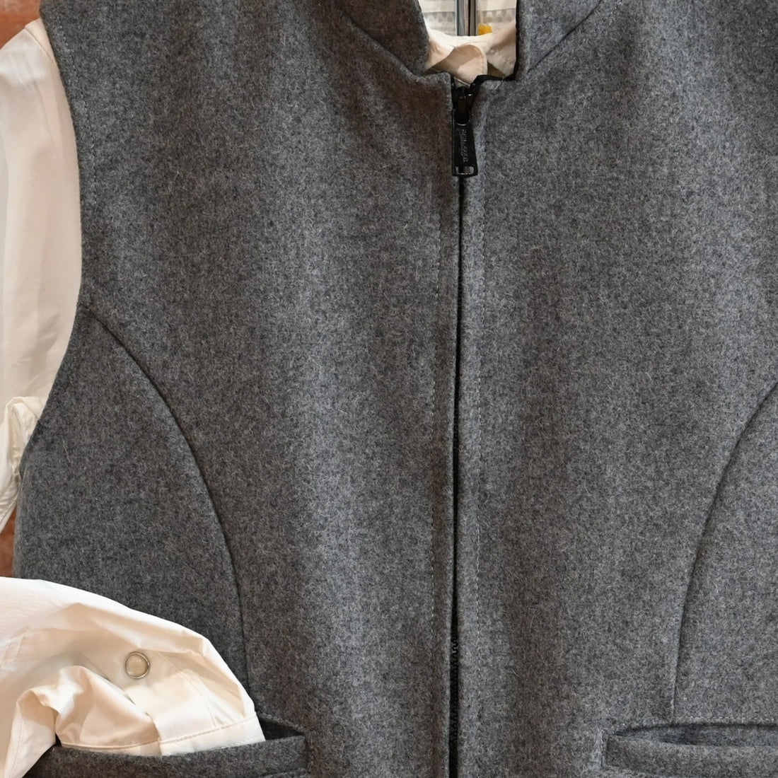 View of Schaefer grey wool vest with zip front, pockets, and adjustable back belt