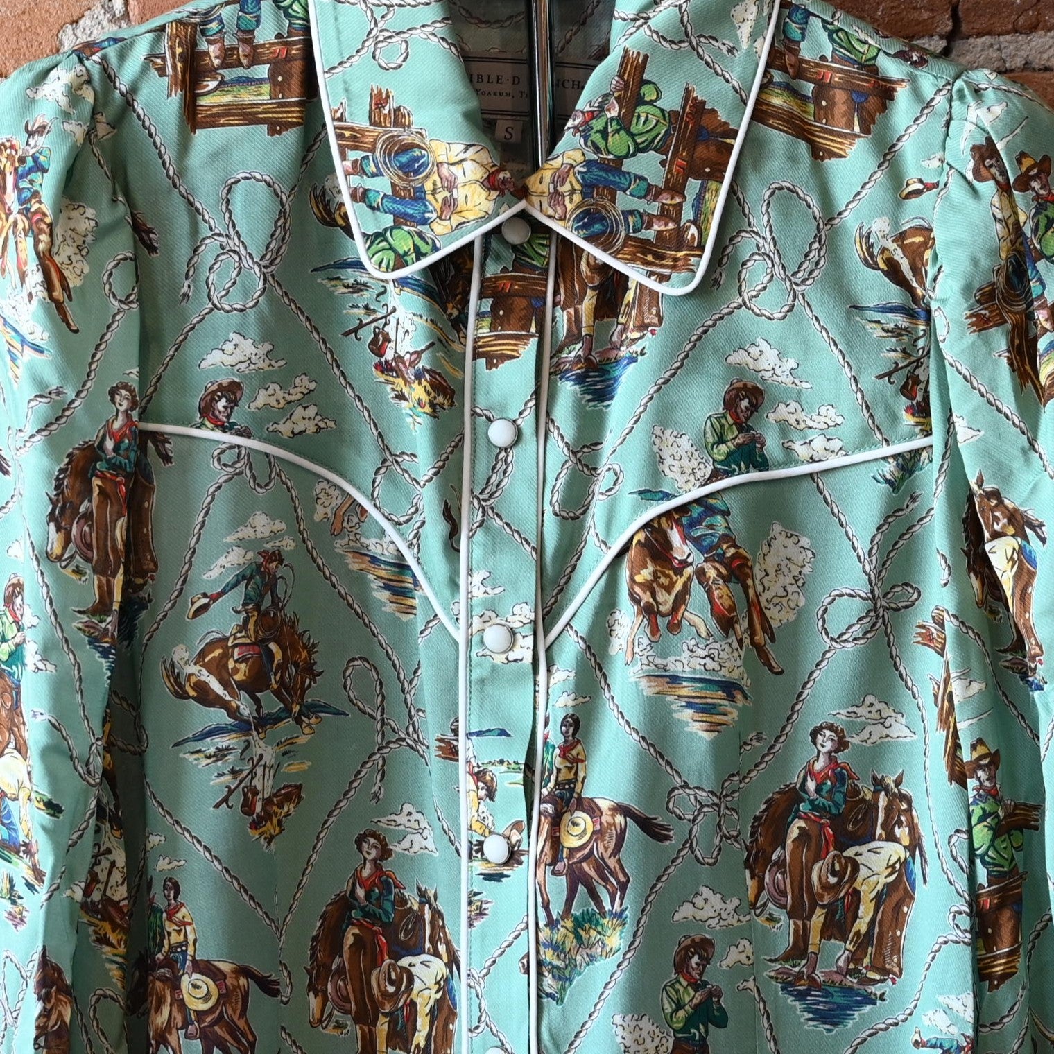 Ladies Romance &amp; Rustlers Top by Double D Ranch with mint-green pulp-art print, pearl snaps, contrast piping, and full cuffed sleeves