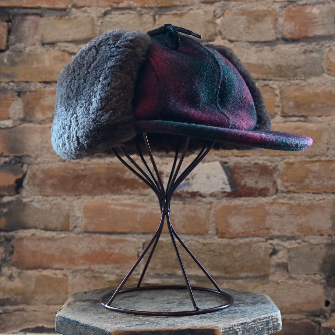 View of Filson Double Mackinaw Cap in Forest Green/Acorn and Burgundy/Dark Olive Plaid featuring shearling-lined earflaps and a 3&quot; bill