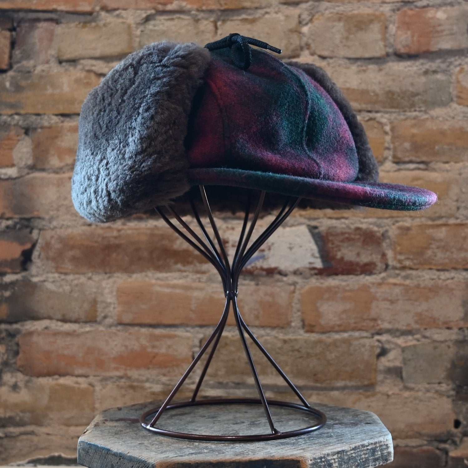 View of Filson Double Mackinaw Cap in Forest Green/Acorn and Burgundy/Dark Olive Plaid featuring shearling-lined earflaps and a 3&quot; bill