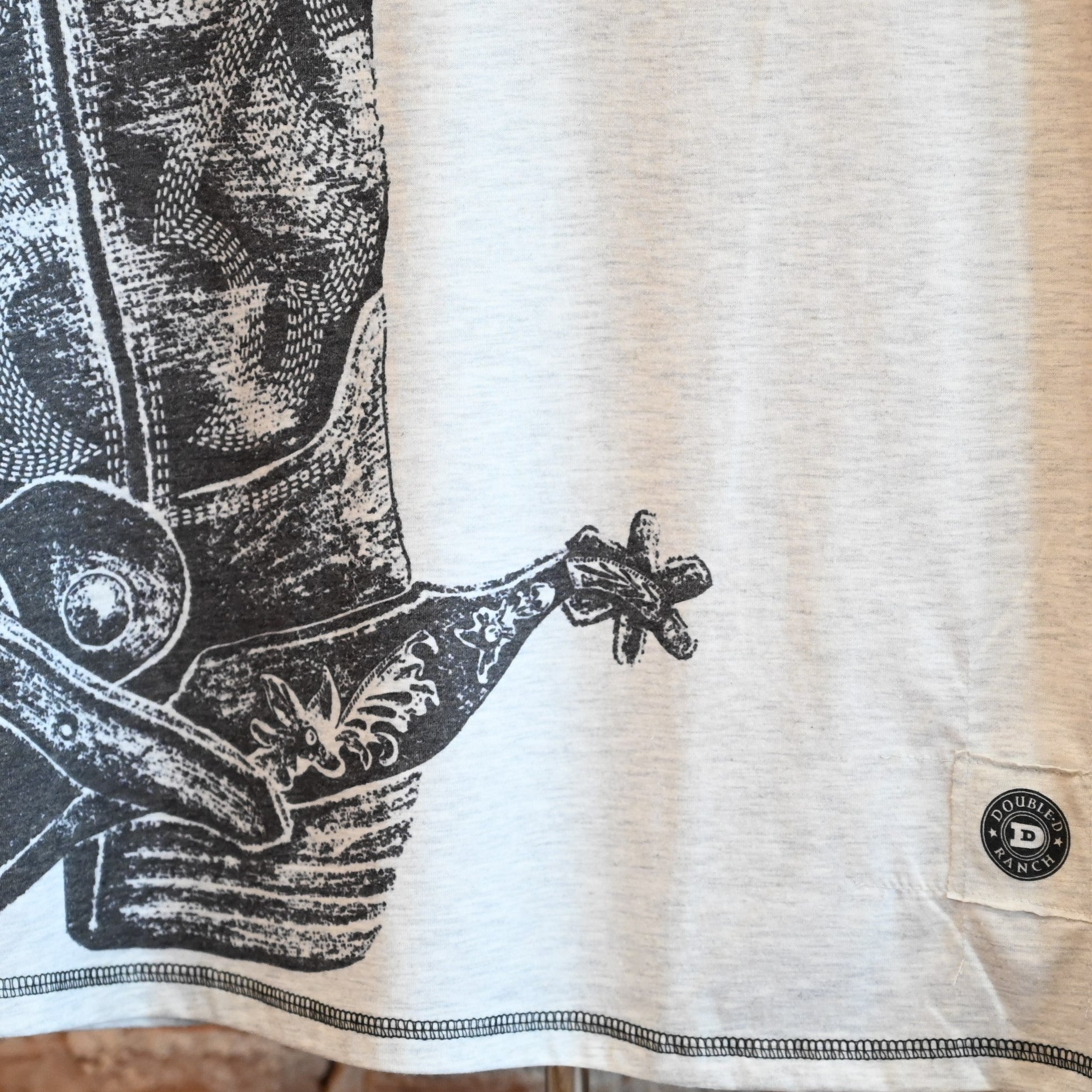 View of Double D Ranch Hide Tickler Top – Silver Spur top with spurred cowboy boot graphic and bandana-patterned sleeves for a Western-inspired look