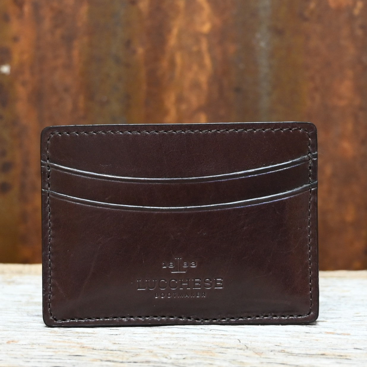 View of Lucchese brown leather credit card case with contrast stitching and slim, flat design