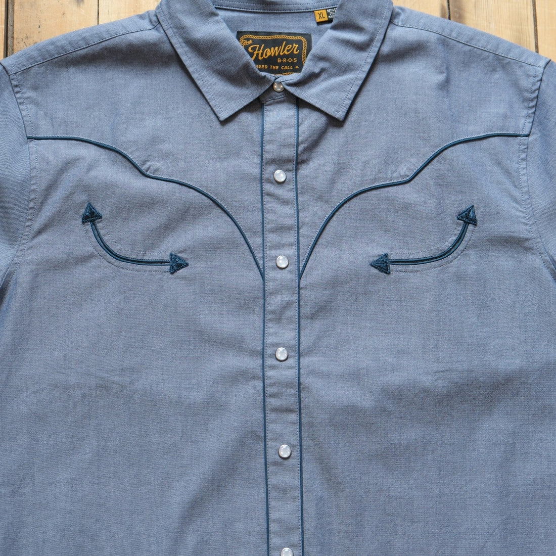 Howler Brothers Broncbuster snapshirt in Indigo featuring contrast piping and pearl snaps.
