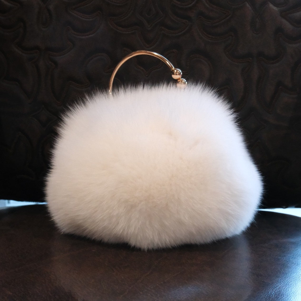 Morris Kaye white fox fur purse with gold ring handle and chain strap