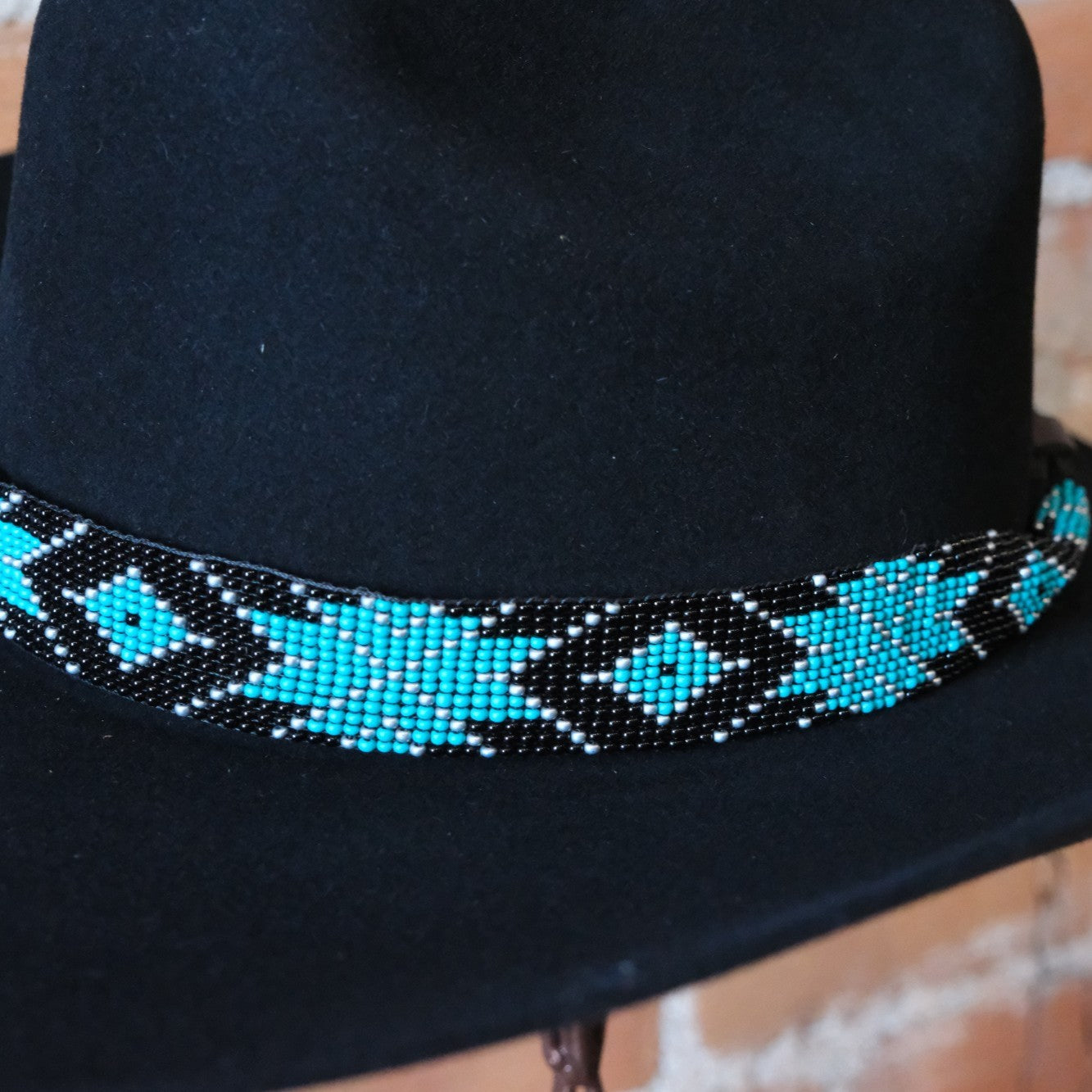 Adjustable Sambboho Saint Barth beaded hatband styled on a black western felt hat at Atomic 79.