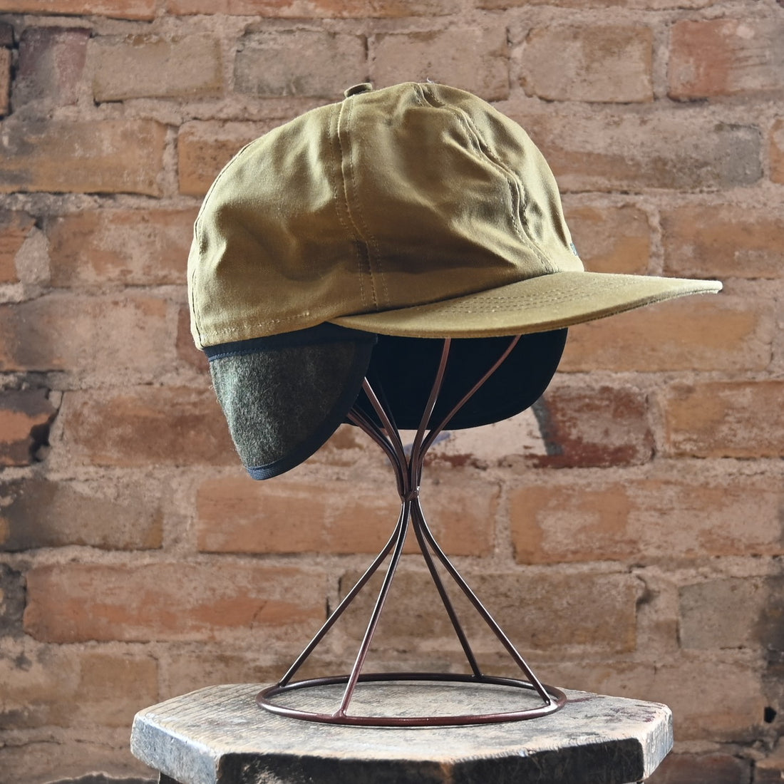 View of Filson Insulated Tin Cloth Cap in Dark Tan featuring wool ear/neck flap and 3&quot; pre-curved bill