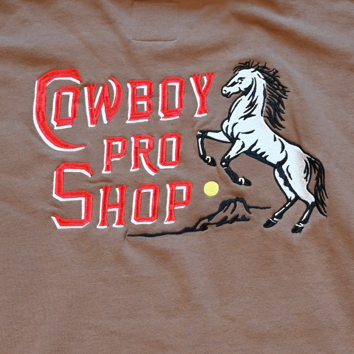 Crewneck sweatshirt with “Cowboy Pro Shop” and horse silhouette graphic in Western style