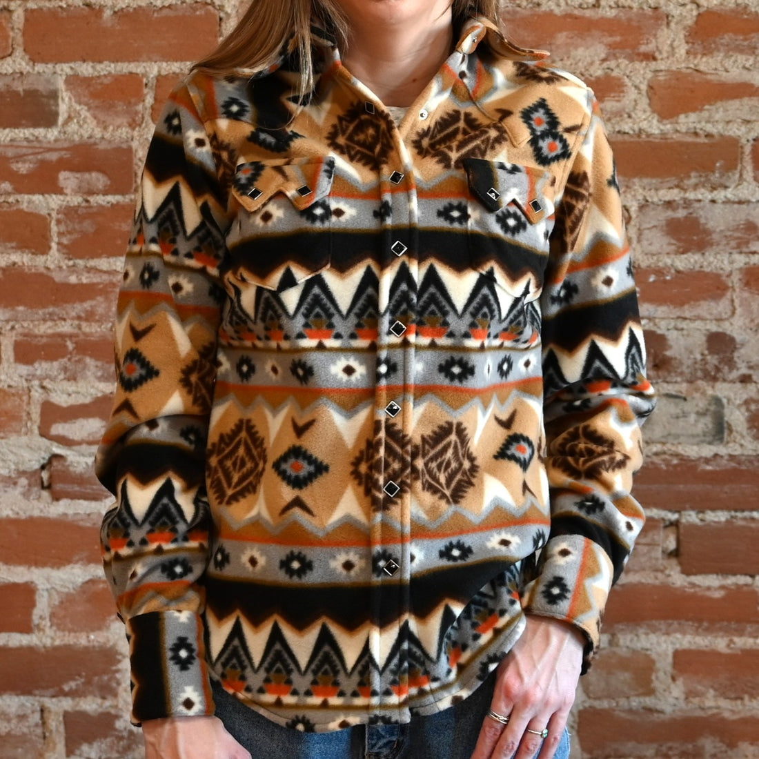 View of Tan and black fleece Western shirt with Native geometric pattern and snap closures