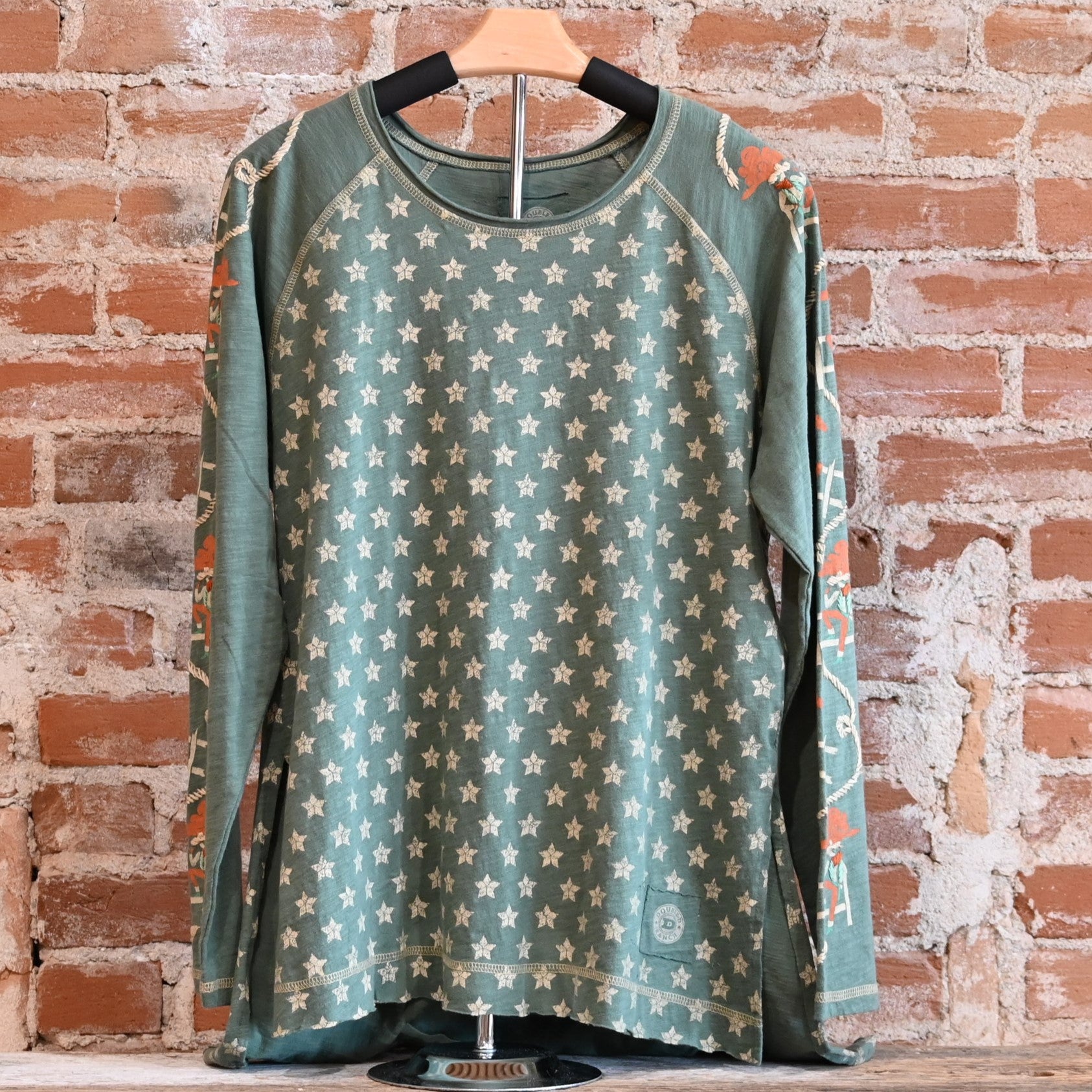 View of Double D Ranch Cowboys Up My Sleeve Top – Button-down top in Garcitas Green with cowboy-inspired print and a relaxed, flattering fit