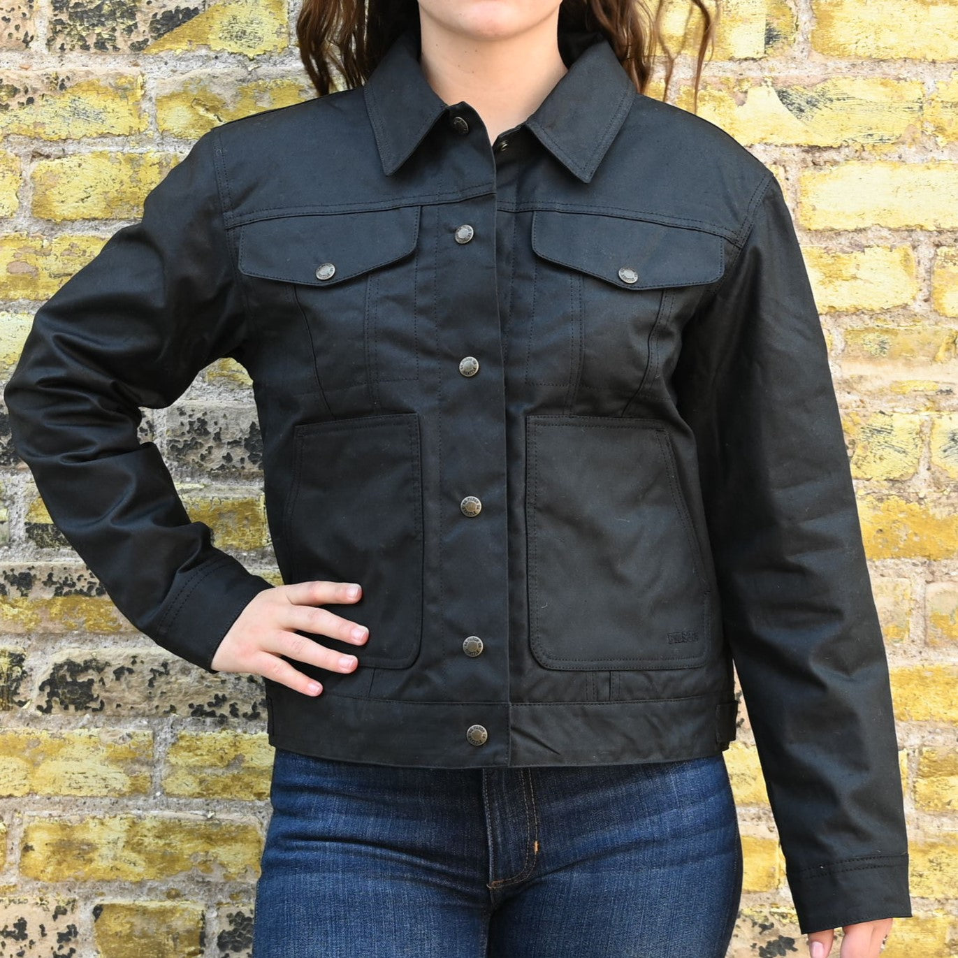 View of Filson Ladies Short Lined Cruiser in Black featuring adjustable cuffs and hem, with a relaxed fit and waxed cotton construction
